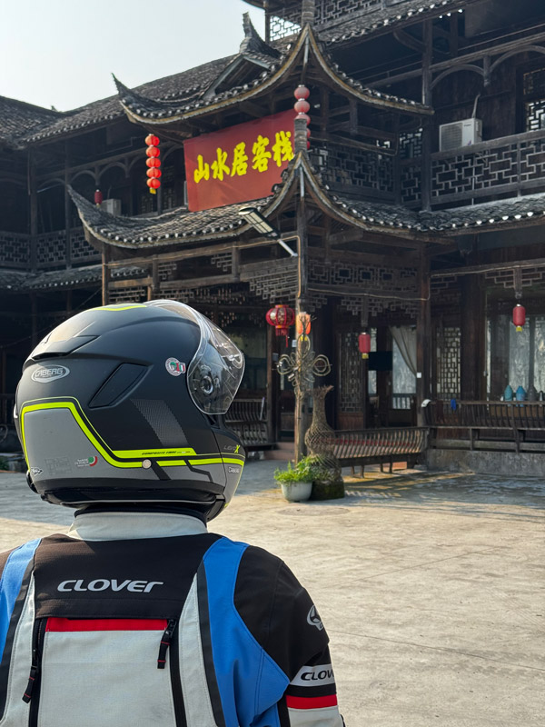 Rider wearing LEVO X flip-up helmet and looking at a Chinese building